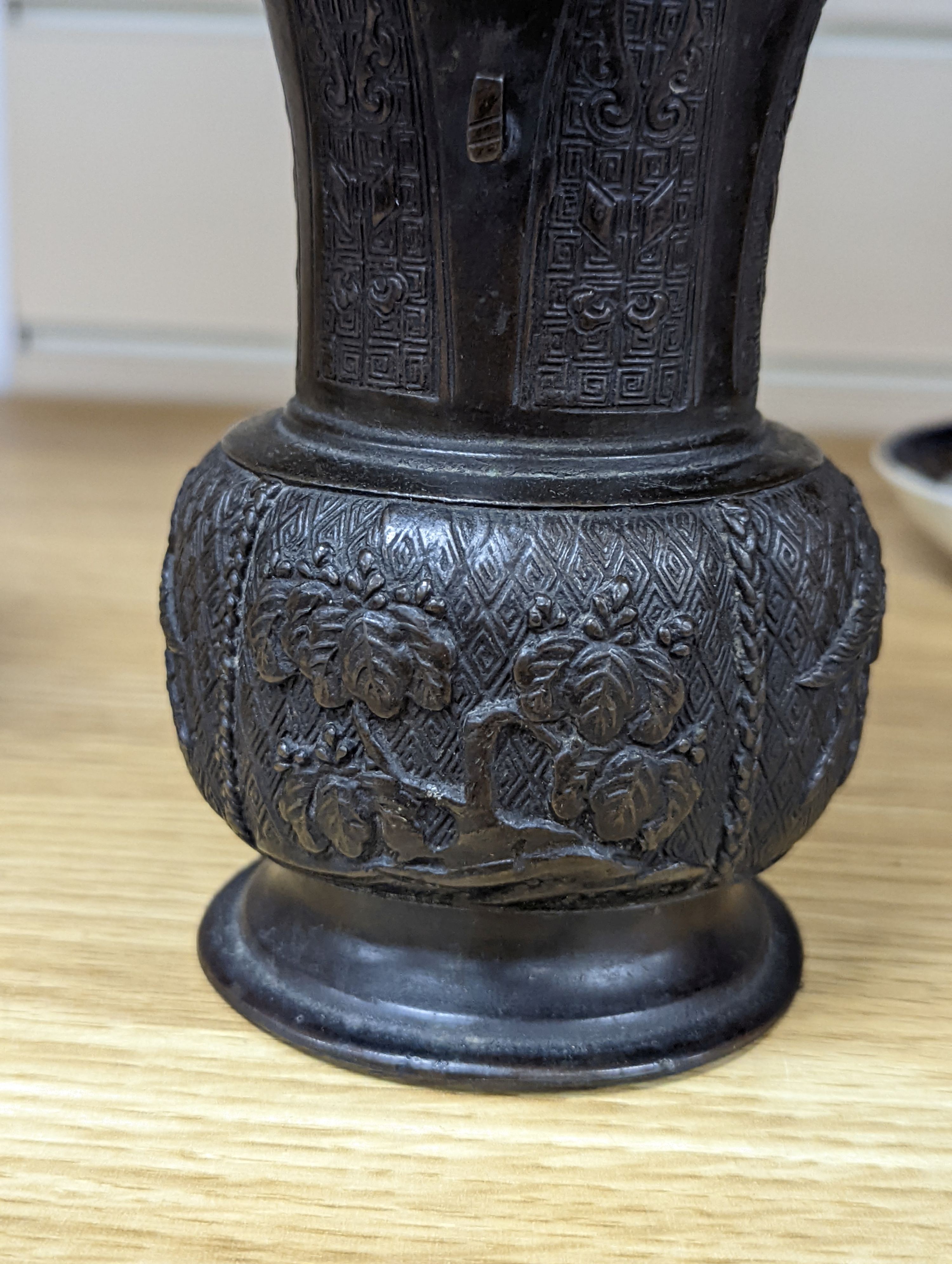 A pair of Japanese Meiji period bronze ‘dragon’ bottle vases and another, 21cm